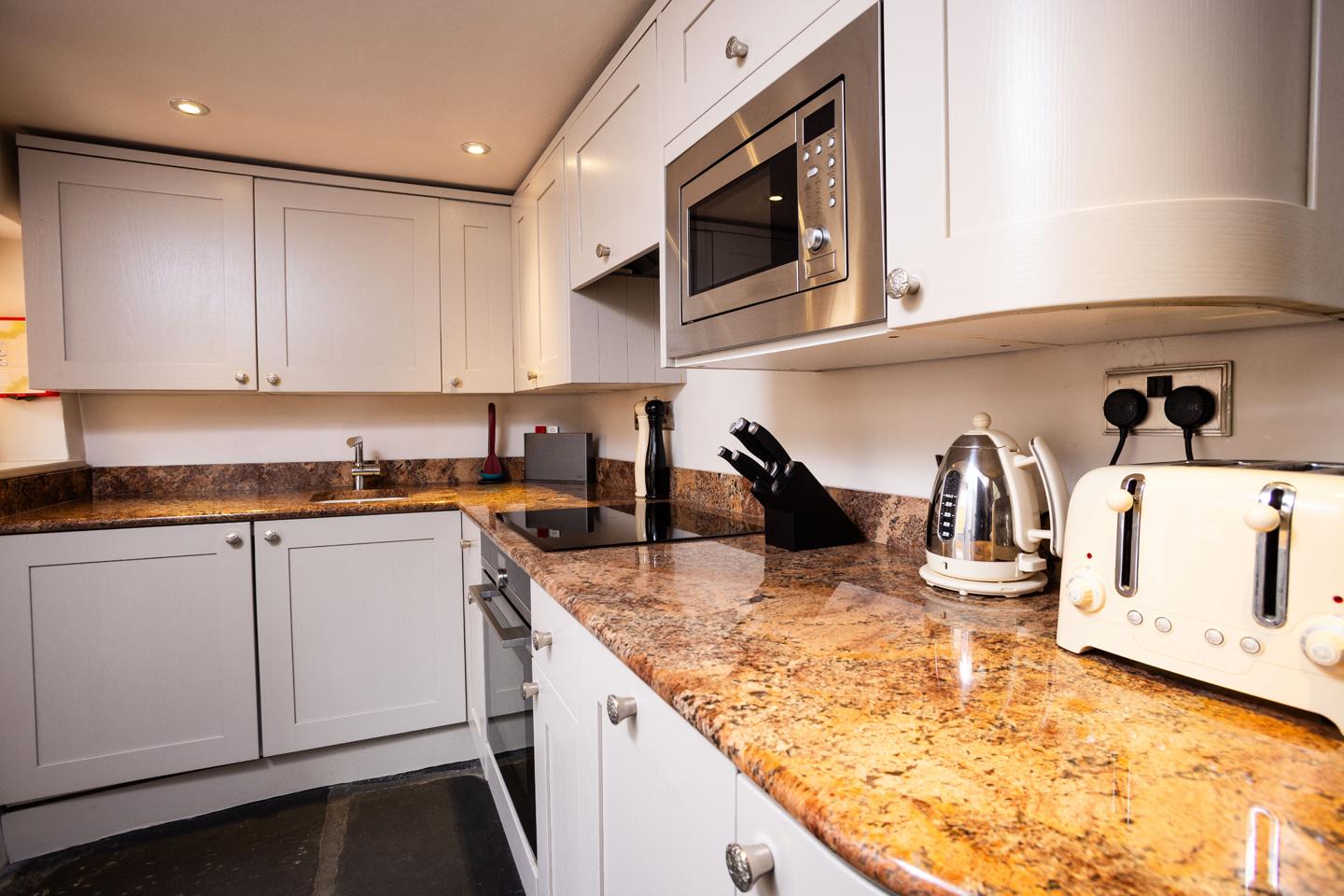 Well-equipped kitchen with original slate flooring and modern appliances