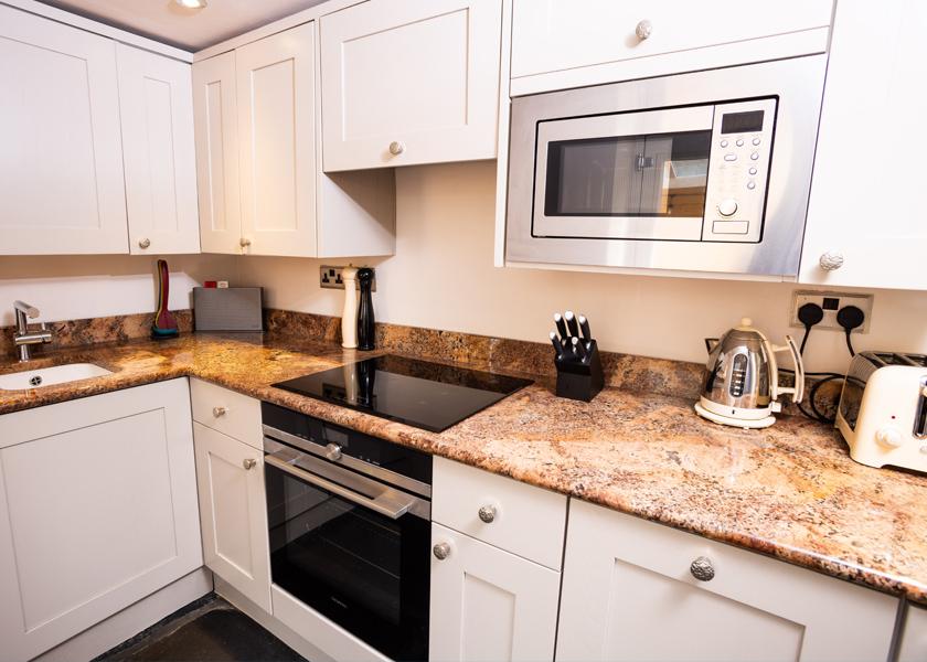 Well-equipped kitchen with original slate flooring and modern appliances