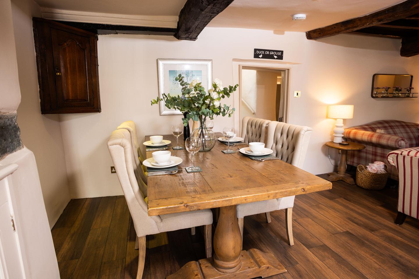 Wooden dining table set for four in a cosy open-plan living space